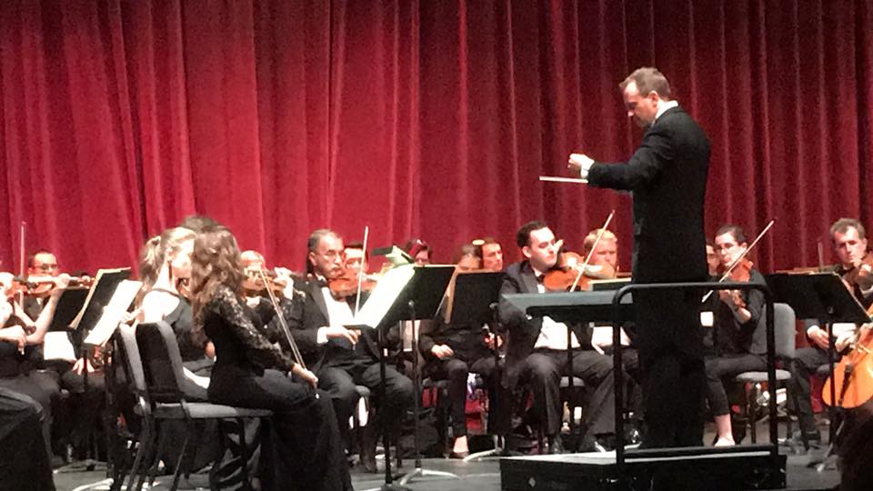 Nick Ost, team member of Artsy & Me, conducting an orchestra. 